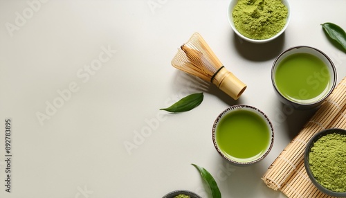 composition with cups of fresh matcha tea powder and accessories on light background