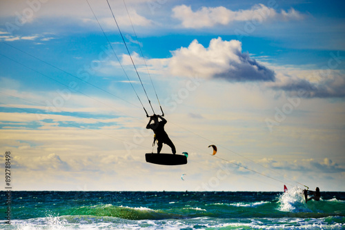 Kite surfer riding waves. Kiteboarding sport.