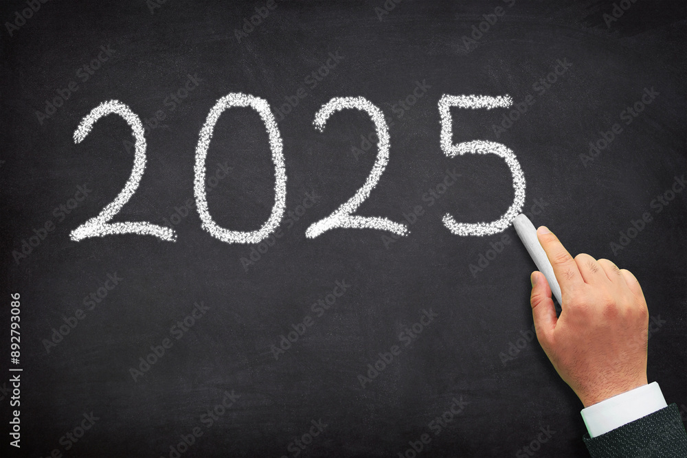 2025 New year concept. A male hand writing new year 2025 on chalkboard. 2025 New year concept. A male hand writing new year 2025 on chalkboard.