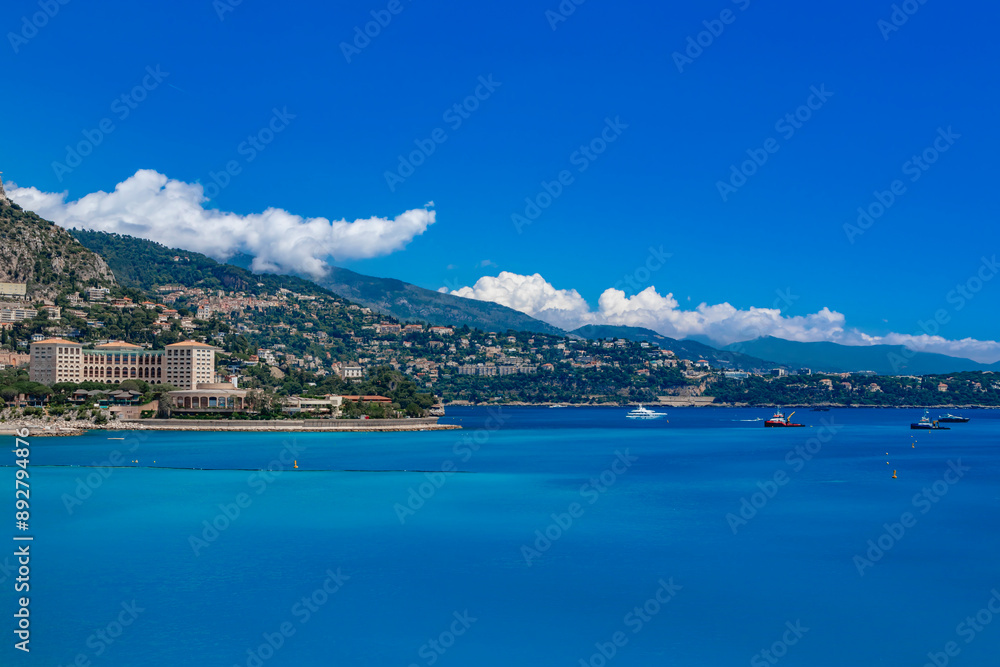 Obraz premium Capture the beauty of the Mediterranean Sea with boats and majestic mountains in the distance. Monaco. Monte Carlo.
