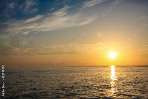 beautiful and colorful sunset, warm light and many clouds, sea waves on the sea coast