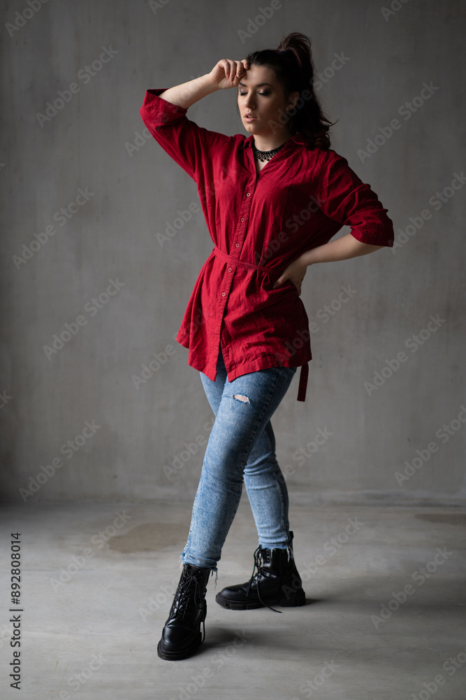 a beautiful young girl in a red shirt with a necklace with a handmade ornament on her neck is posing in a photo studio a beautiful young girl in a red shirt with a necklace with a handmade ornament on her neck is posing in a photo studio