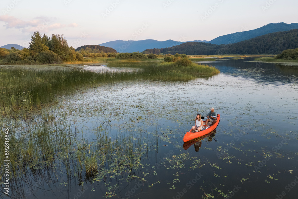 Happy young couple having fun and enjoying canoeing on a summer lakeshore vacation. Savor the moment concept. Happy young couple having fun and enjoying canoeing on a summer lakeshore vacation. Savor the moment concept.