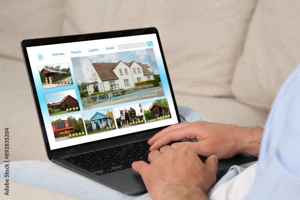 Man choosing dwelling on house hunting website via laptop indoors, closeup Man choosing dwelling on house hunting website via laptop indoors, closeup