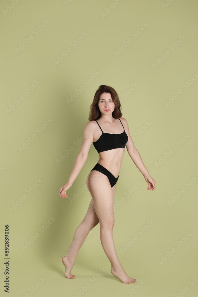 Fototapeta premium Woman with slim body posing on olive background