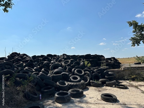 Car tire dump. rubber tires. Industrial landfill for recycling used tires and rubber tires. A pile of old tires and wheels for rubber recycling. Tire dump