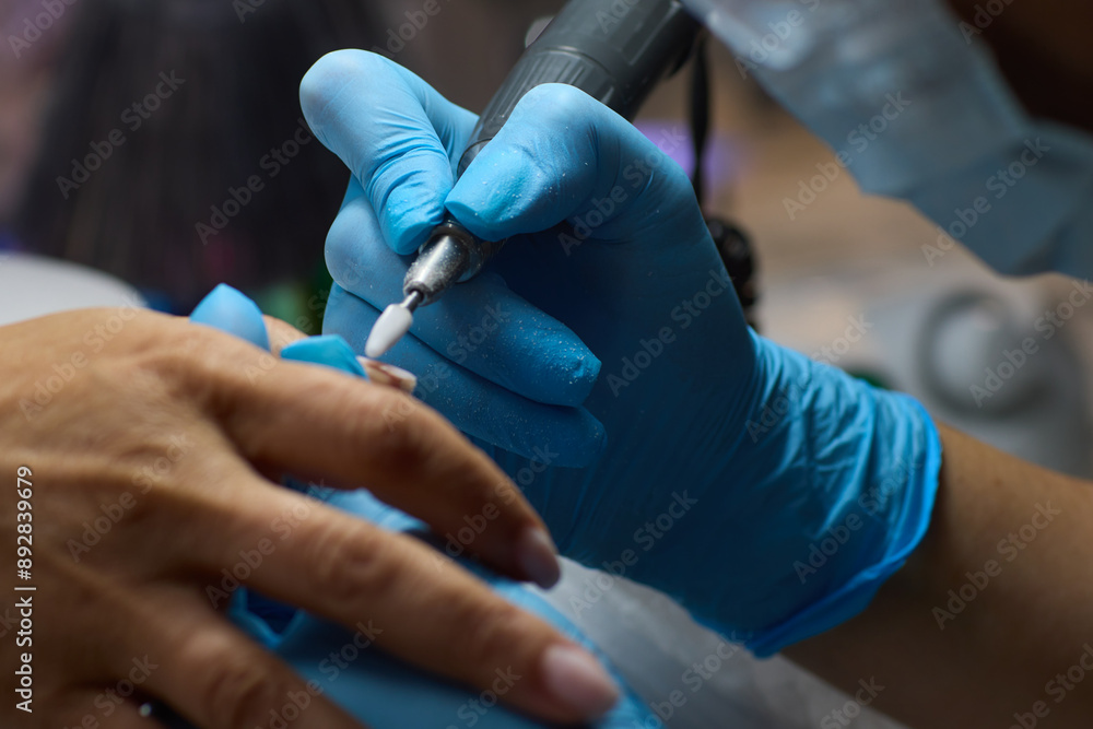 The dental specialist is using modern tools and wearing gloves to perform a precise procedure The dental specialist is using modern tools and wearing gloves to perform a precise procedure