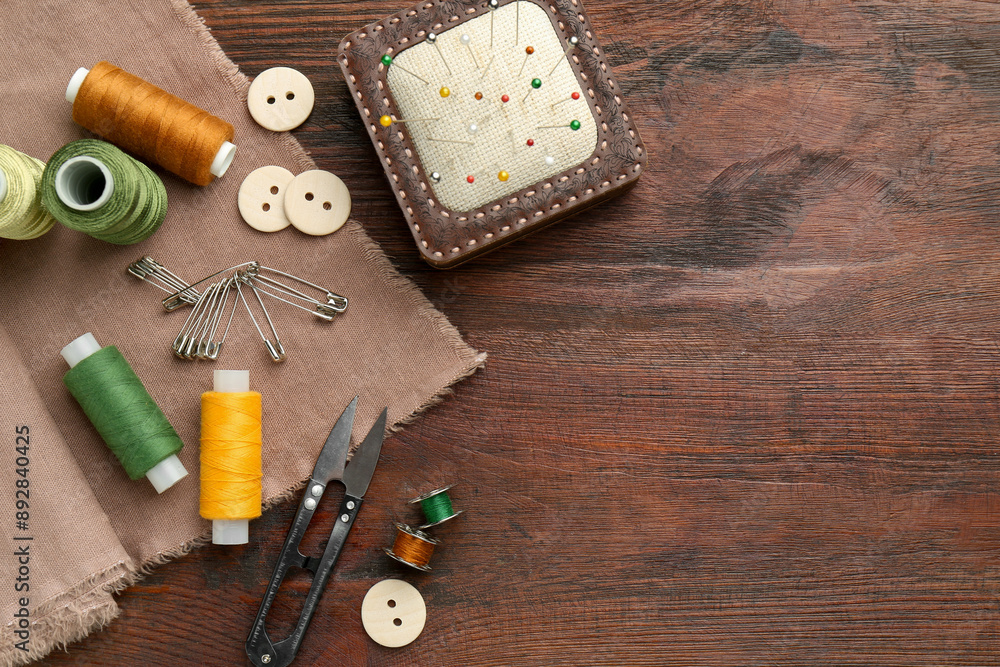 Flat lay composition with different sewing supplies on wooden table. Space for text Flat lay composition with different sewing supplies on wooden table. Space for text