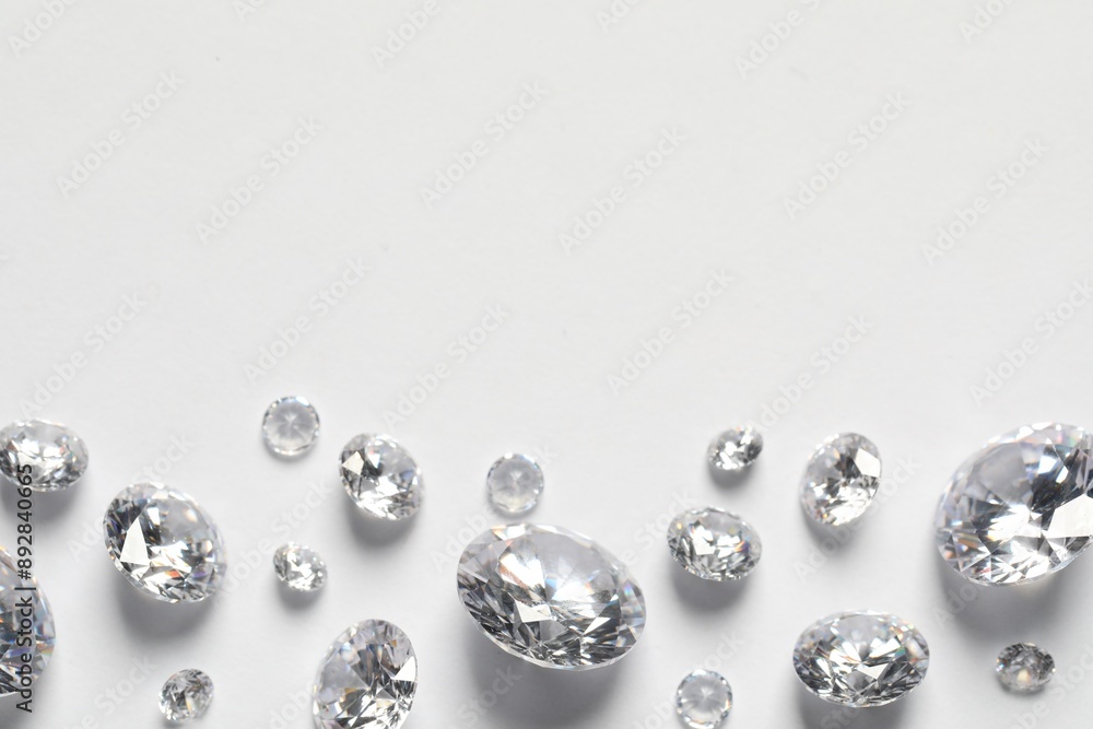 Many beautiful shiny diamonds on white background, flat lay. Space for text Many beautiful shiny diamonds on white background, flat lay. Space for text