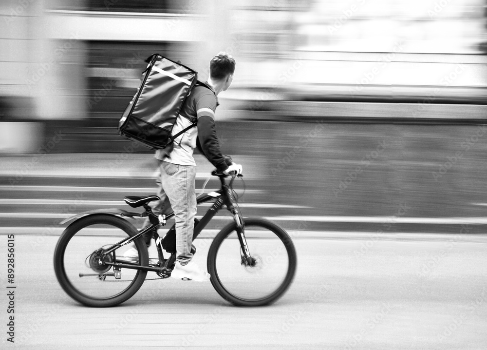 Courier on a bike rides down the street Courier on a bike rides down the street
