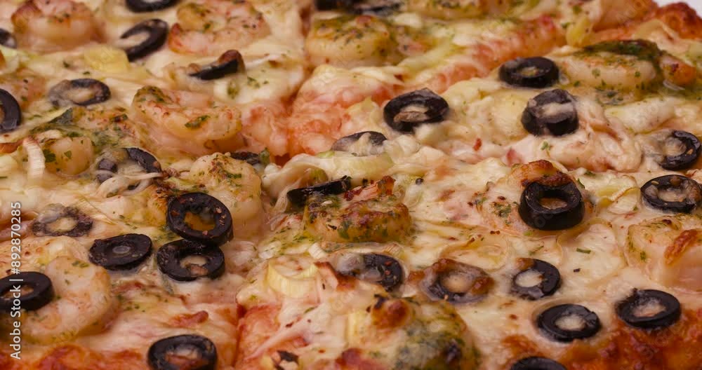 Fried pizza already sliced with seafood and black olives in the overview on the table. Fried pizza already sliced with seafood and black olives in the overview on the table.