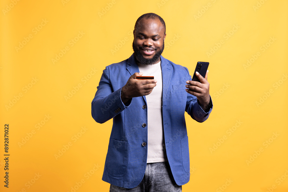 Upbeat man adding payment method on phone, enjoying himself, isolated over studio background. Joyous person delighted to do internet shopping, carefully typing credit card information Upbeat man adding payment method on phone, enjoying himself, isolated over studio background. Joyous person delighted to do internet shopping, carefully typing credit card information
