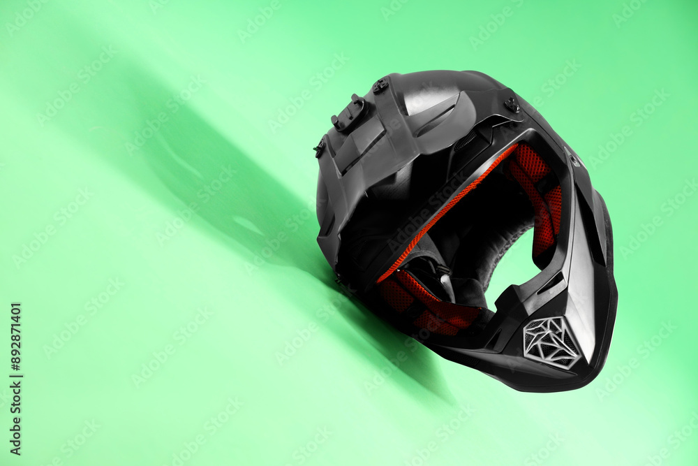 Modern motorcycle helmet with visor on light green background. Space for text Modern motorcycle helmet with visor on light green background. Space for text