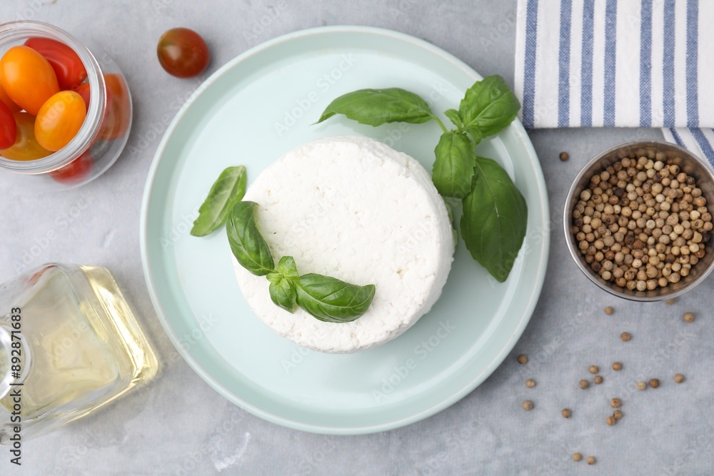 Fresh ricotta (cream cheese) and basil on gray table, flat lay Fresh ricotta (cream cheese) and basil on gray table, flat lay