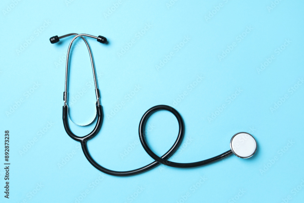Stethoscope on light blue background, top view. Medical treatment Stethoscope on light blue background, top view. Medical treatment