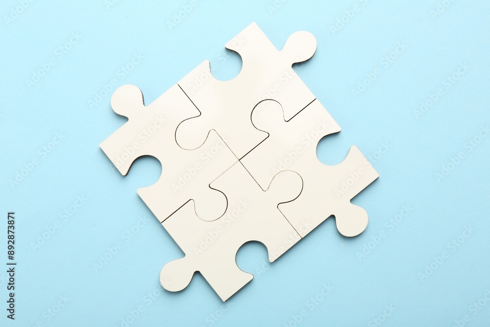 White puzzle pieces on light blue background, top view White puzzle pieces on light blue background, top view