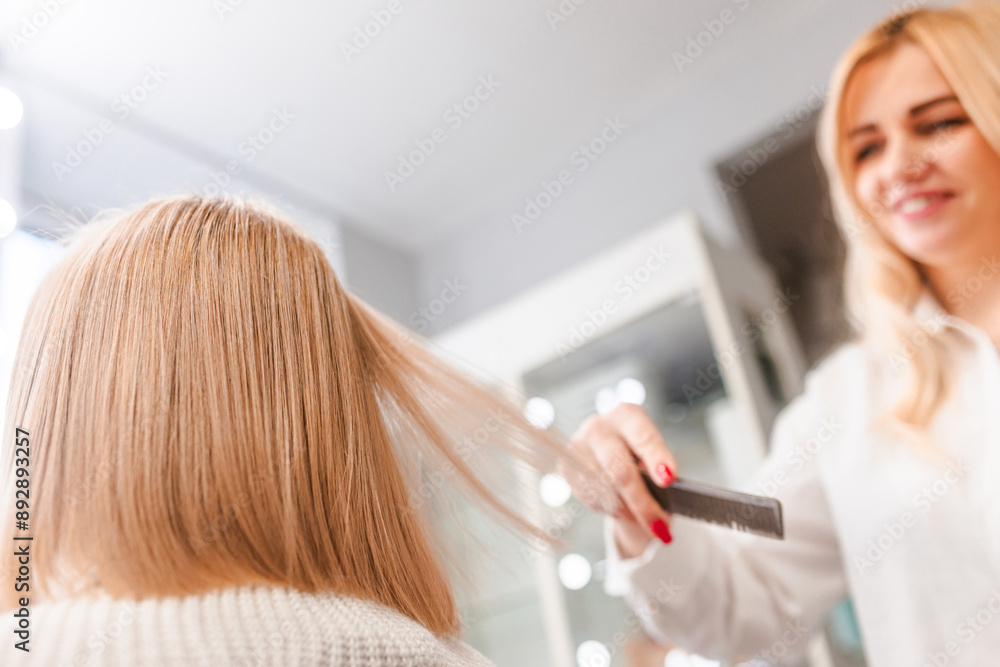 Stylist Combing Blonde Hair in Salon Stylist Combing Blonde Hair in Salon