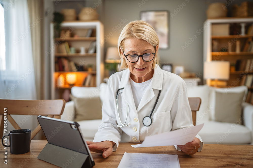 Mature woman doctor work from home on tablet with medical documents Mature woman doctor work from home on tablet with medical documents