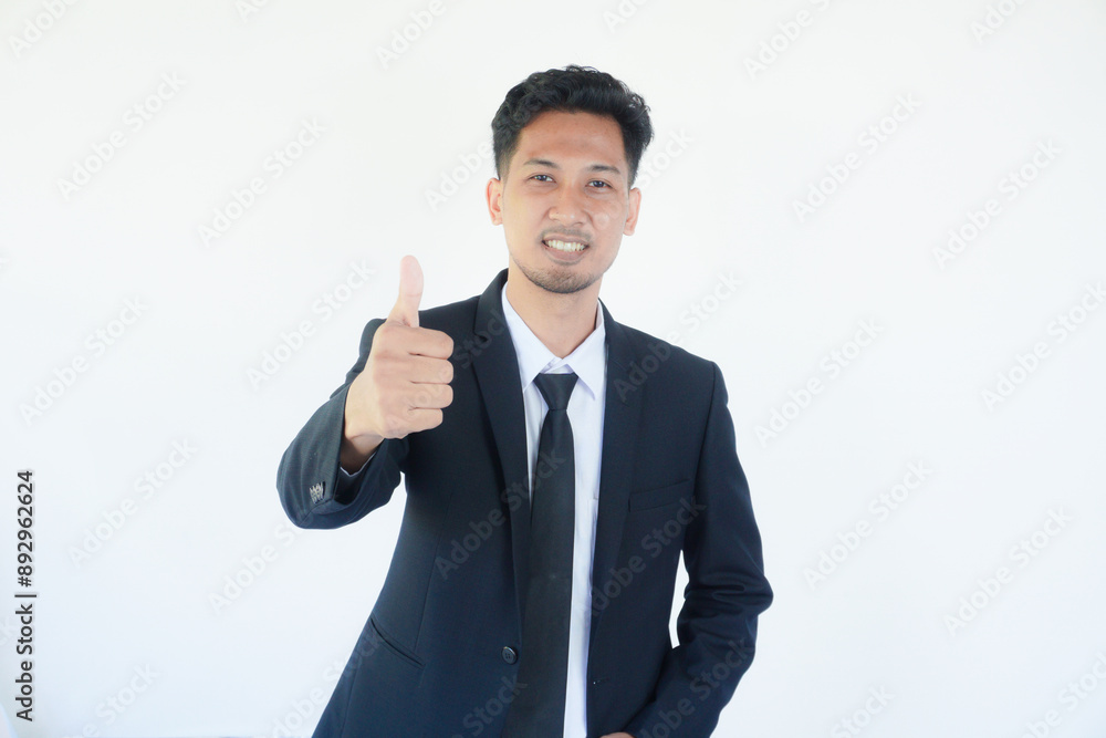 Adult Asian man wearing black suit and tie giving thumb up with happy expression Adult Asian man wearing black suit and tie giving thumb up with happy expression