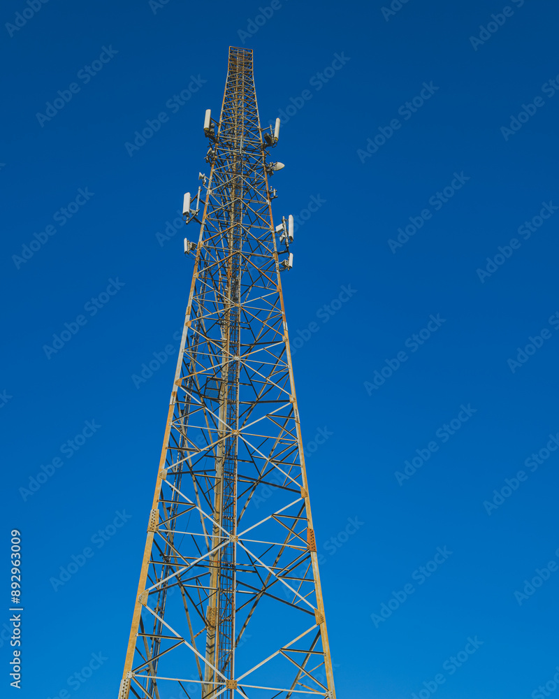Tall Telecommunication Tower Against a Clear Blue Sky Tall Telecommunication Tower Against a Clear Blue Sky