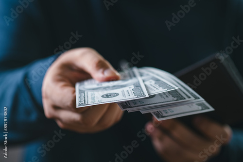 Фотография Close-up of a person handing over US dollar bills