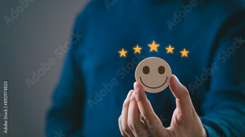 Canvas Print Hand holding a happy face coin with five stars above, representing excellent customer satisfaction and positive feedback