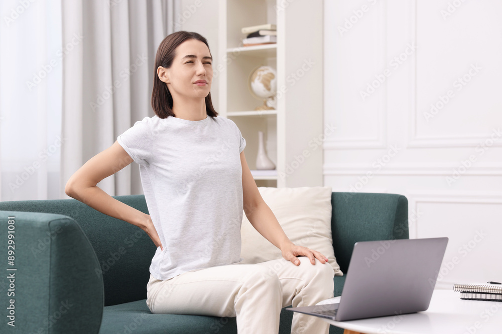 Woman suffering from back pain at home. Symptom of poor posture Woman suffering from back pain at home. Symptom of poor posture