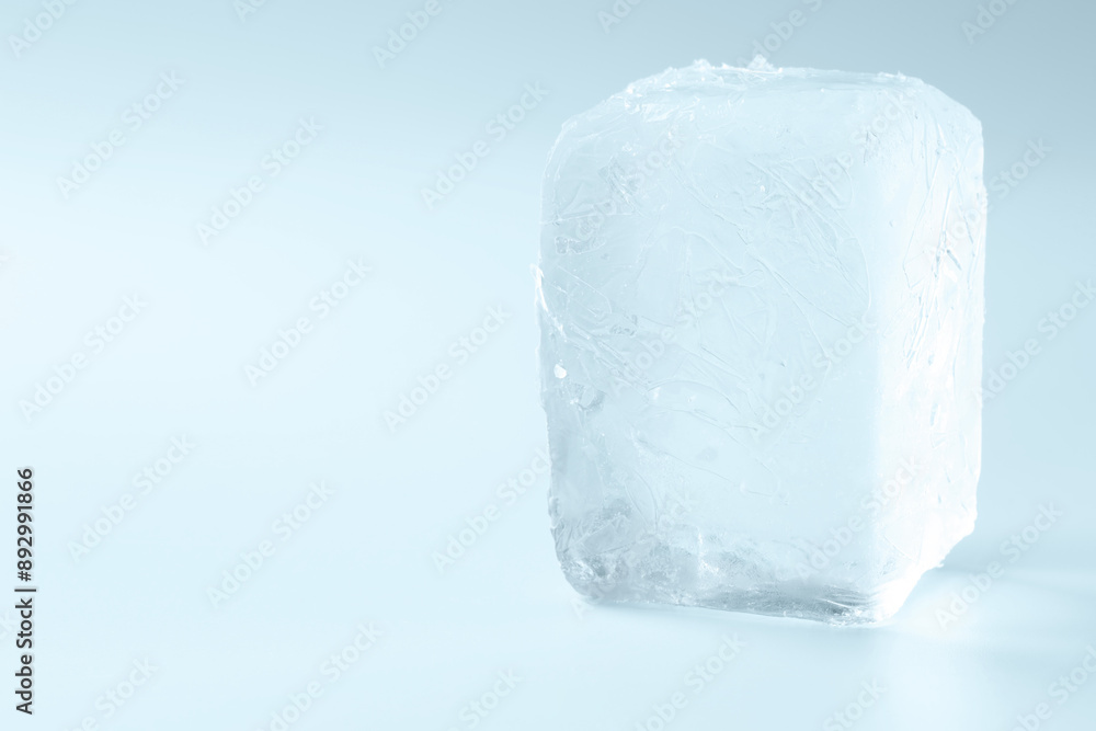 Cube of clear ice on light blue background, space for text Cube of clear ice on light blue background, space for text