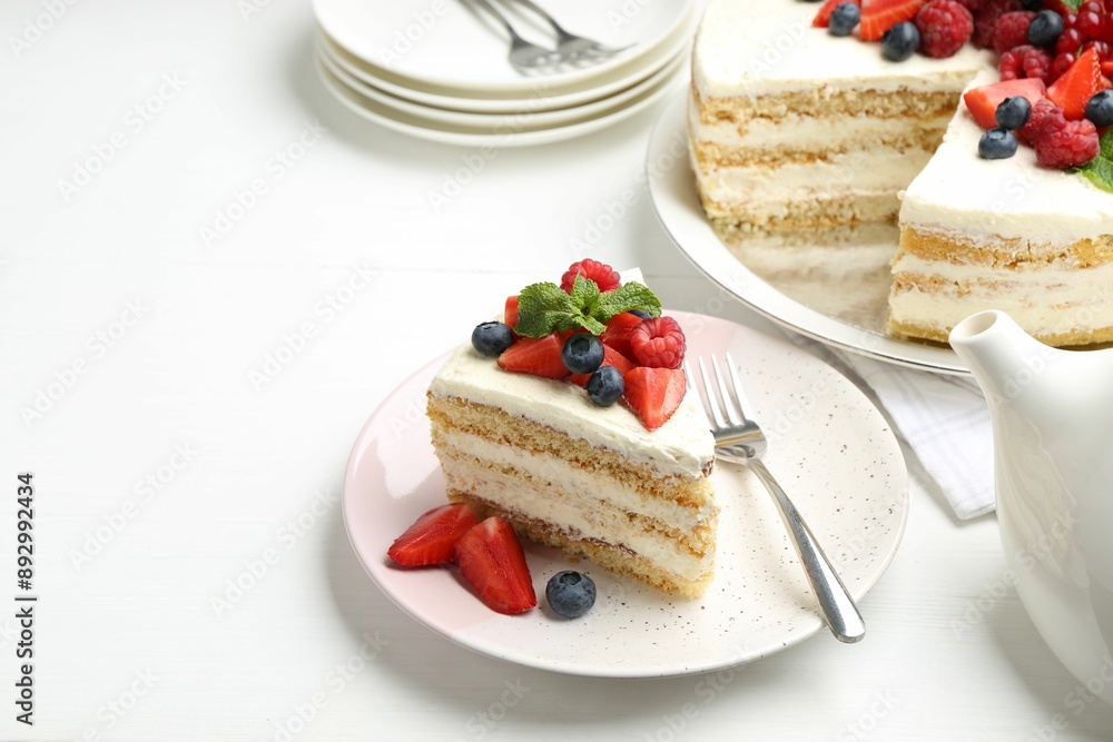 Tasty sponge cake with fresh berries and mint served on white table, space for text Tasty sponge cake with fresh berries and mint served on white table, space for text