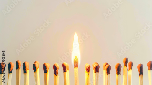 Single Lit Match Among Unlit Matches on White Background