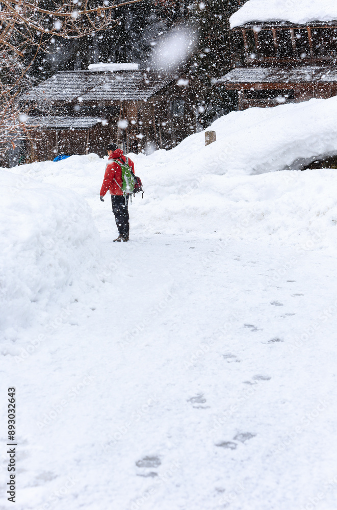 Man dress in red walking in the Shirakawa-go village Man dress in red walking in the Shirakawa-go village