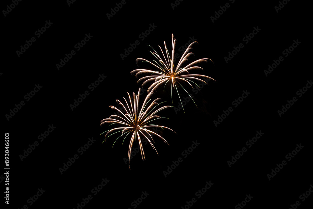 A beautiful color time lapse photo of two exploding fireworks isolated against a dark black night sky with copy space. A beautiful color time lapse photo of two exploding fireworks isolated against a dark black night sky with copy space.