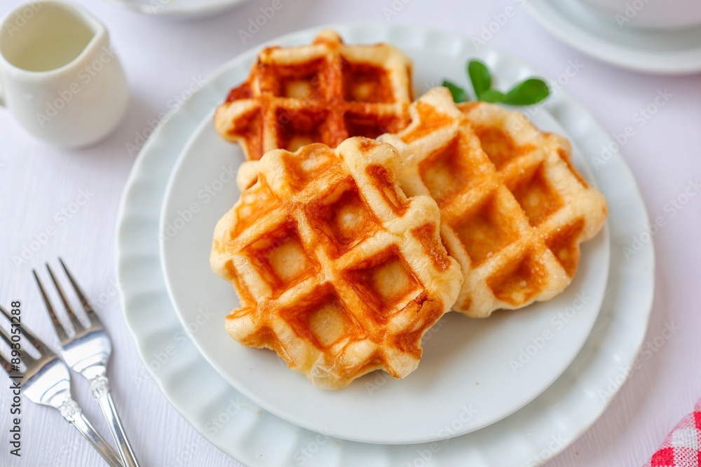 Waffles in white plate on white background with fork Waffles in white plate on white background with fork
