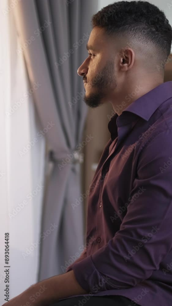 Vertical video. Morning inspiration. New day. Home leisure. Relaxed satisfied pensive guy enjoying drinking hot tea at window at light home interior with free space. Vertical video. Morning inspiration. New day. Home leisure. Relaxed satisfied pensive guy enjoying drinking hot tea at window at light home interior with free space.
