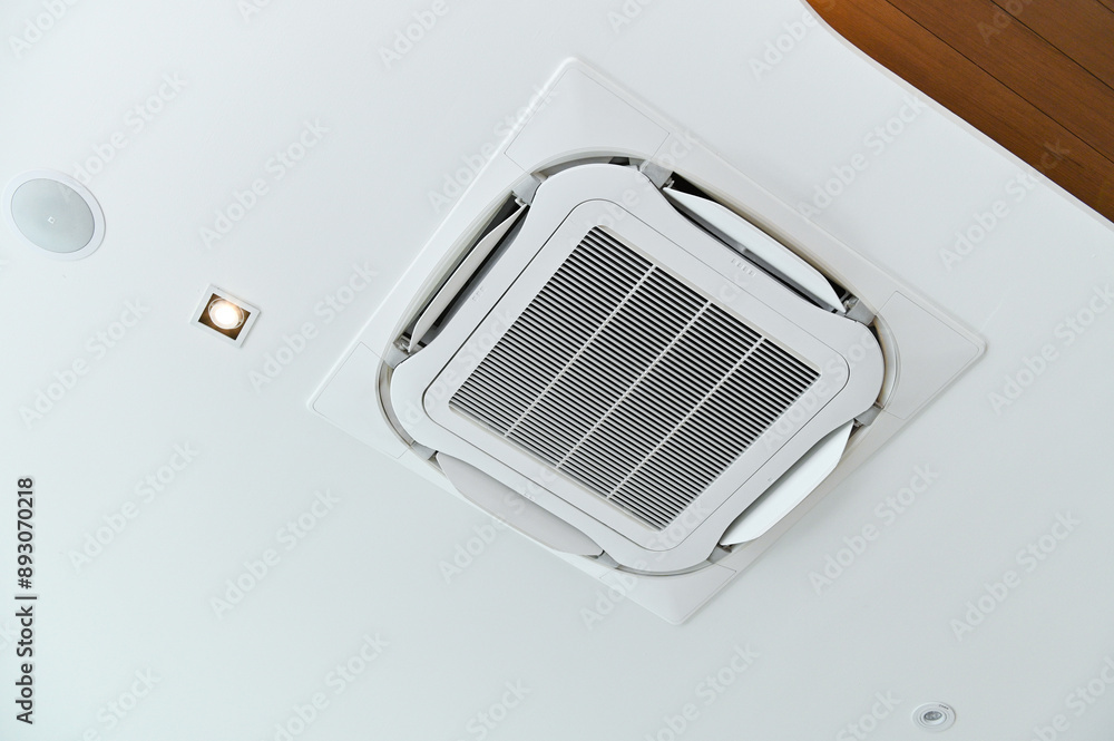 Ceiling-mounted air conditioner with integrated light, showcasing modern HVAC design. Ceiling-mounted air conditioner with integrated light, showcasing modern HVAC design.