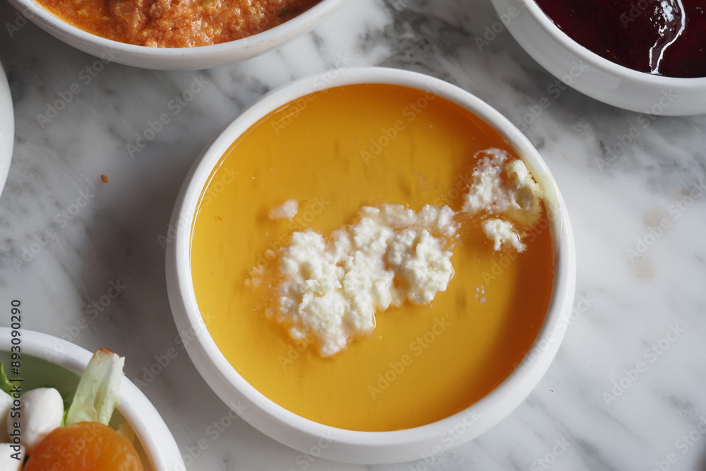 butter cream and honey in a bowl on table . butter cream and honey in a bowl on table .