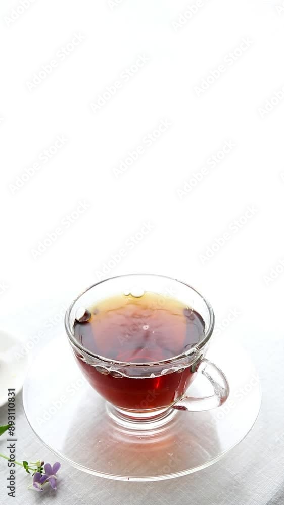 pouring tea in a glass cup, sunny bright day, vertical video pouring tea in a glass cup, sunny bright day, vertical video