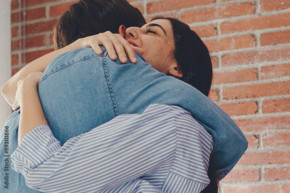 Excited couple hugging each other at home in happy moment indoor. Love and relationship concept. Friendship and celebration. Meet after long time emotion parents brothers sisters Excited couple hugging each other at home in happy moment indoor. Love and relationship concept. Friendship and celebration. Meet after long time emotion parents brothers sisters