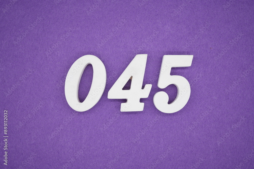 The numbers are made of white paint wood, placed on the background as a purple paper. The numbers are made of white paint wood, placed on the background as a purple paper.