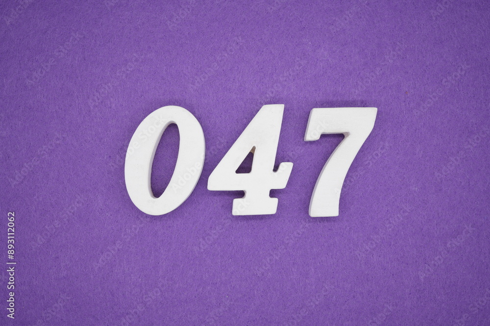 The numbers are made of white paint wood, placed on the background as a purple paper. The numbers are made of white paint wood, placed on the background as a purple paper.