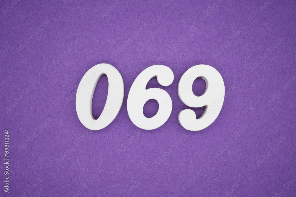 The numbers are made of white paint wood, placed on the background as a purple paper. The numbers are made of white paint wood, placed on the background as a purple paper.