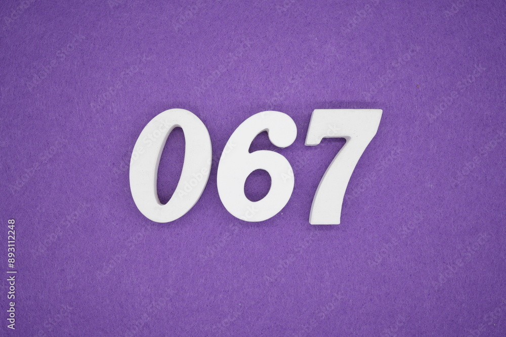 The numbers are made of white paint wood, placed on the background as a purple paper. The numbers are made of white paint wood, placed on the background as a purple paper.