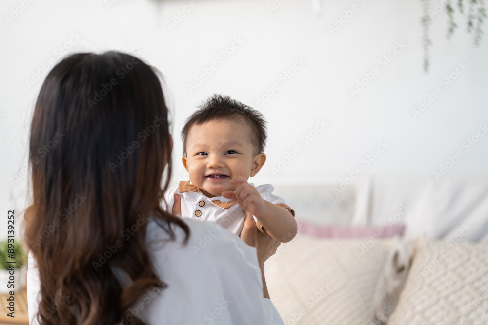 Portrait of enjoy happy love family asian mother playing with adorable little asian baby.Mom touching with cute son moments good time in a white bedroom.Love of family concept Portrait of enjoy happy love family asian mother playing with adorable little asian baby.Mom touching with cute son moments good time in a white bedroom.Love of family concept