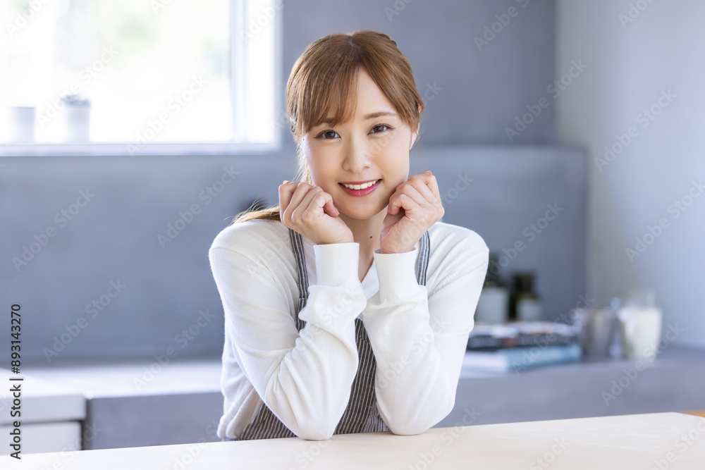 キッチンで頬杖をついた笑顔の女性