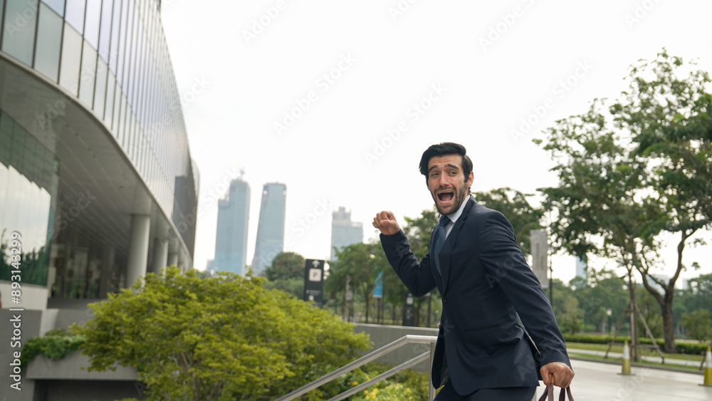 Dancing business man walking and hold bag while dancing at park. Happy funny project manager moving body to music while going to work. Happy man getting promotion, receive good news. Exultant. Dancing business man walking and hold bag while dancing at park. Happy funny project manager moving body to music while going to work. Happy man getting promotion, receive good news. Exultant.