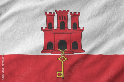 Giblartar flag depicted on folded wavy fabric of old cloth close up