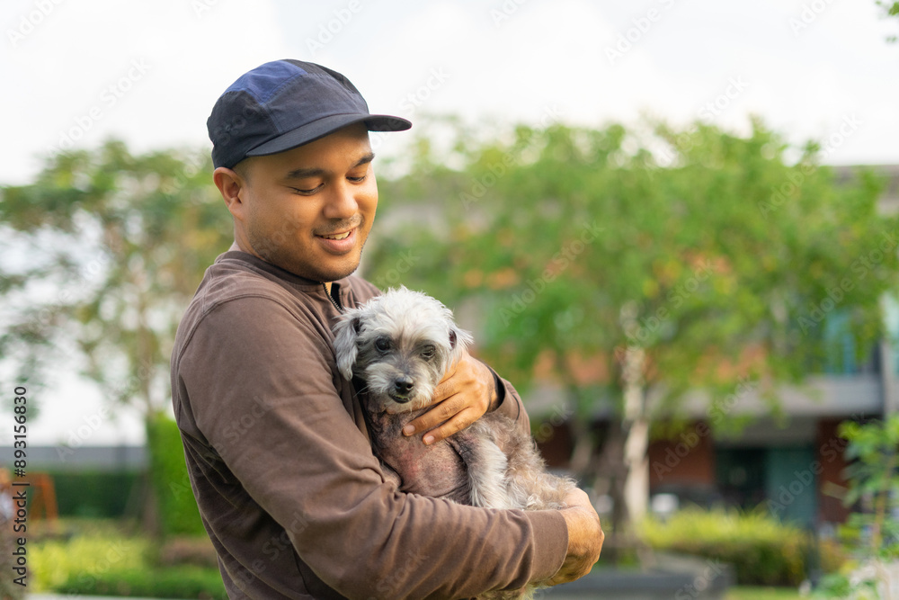 Yong asian man in casual outfit of cheerful with old dog at outdoors. Male playing with her little adopted dog pet and owner having good time together. Hugs and kisses, Love, Care, Friendship Yong asian man in casual outfit of cheerful with old dog at outdoors. Male playing with her little adopted dog pet and owner having good time together. Hugs and kisses, Love, Care, Friendship