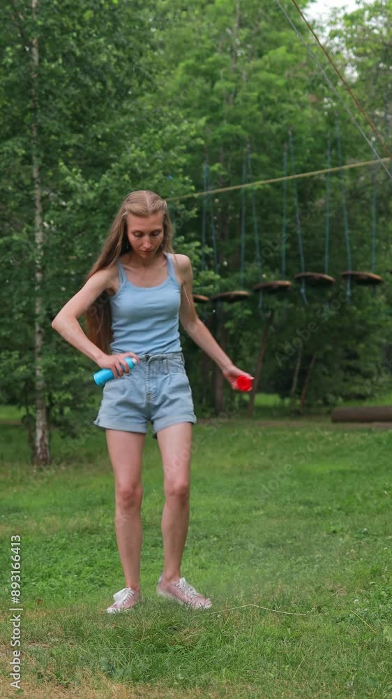Woman applying mosquito repellent while walking in the park Woman applying mosquito repellent while walking in the park