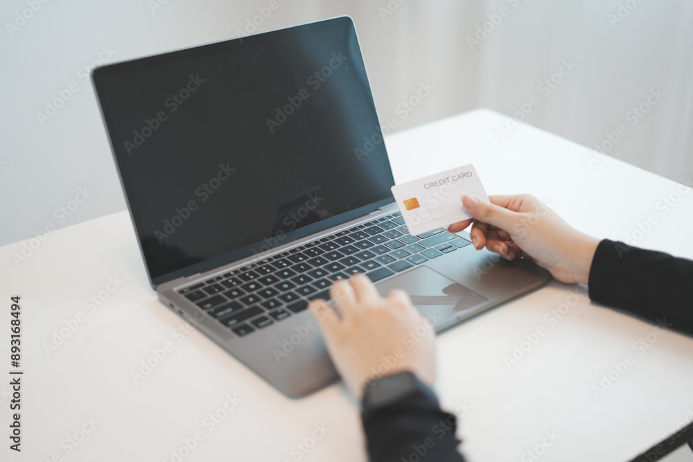 Asian woman's hand holding mock-up credit card, spending online shopping at home office. Asian woman's hand holding mock-up credit card, spending online shopping at home office.