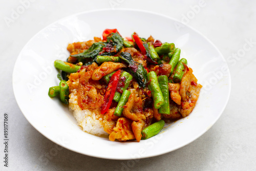 Rice topped with stir fried pork and red curry paste with yard-long bean